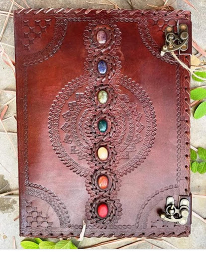 Brown leather journal with chakra stone design on a natural background